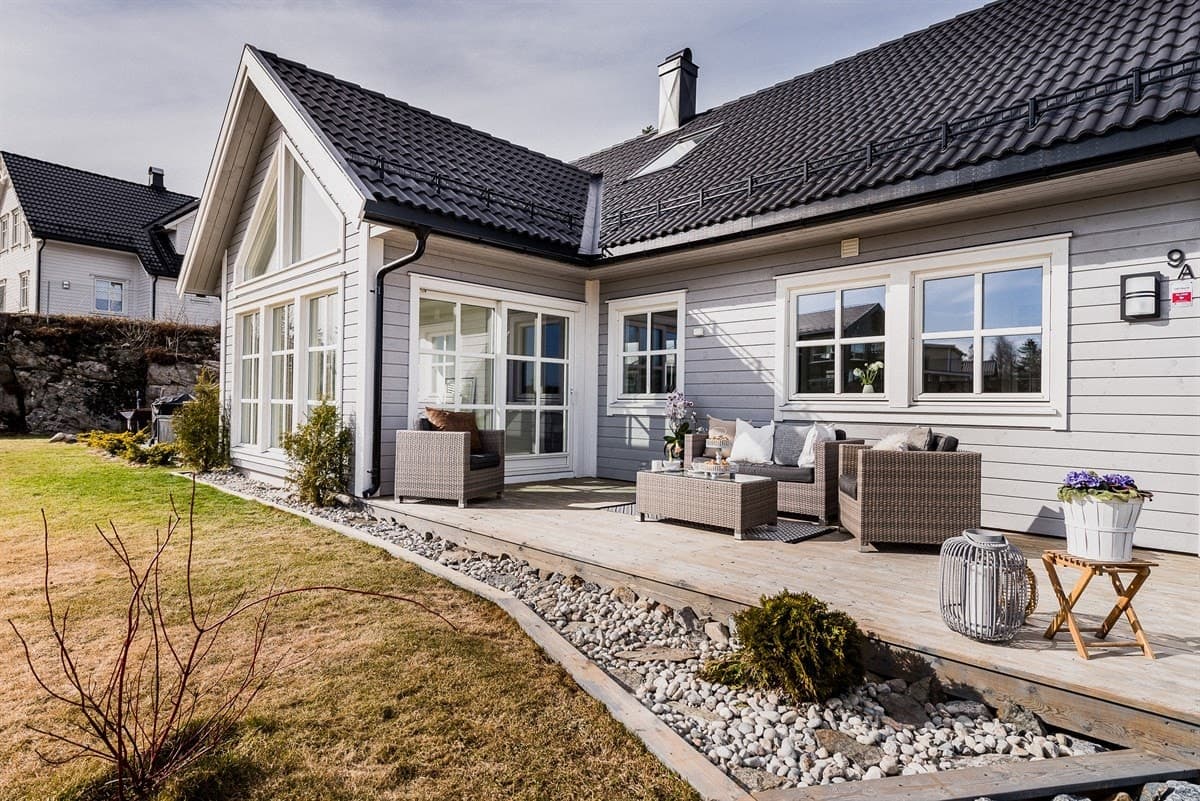 Eneboligen sett fra hagen, med terrasse og sittegruppe langs fasaden, Vestby