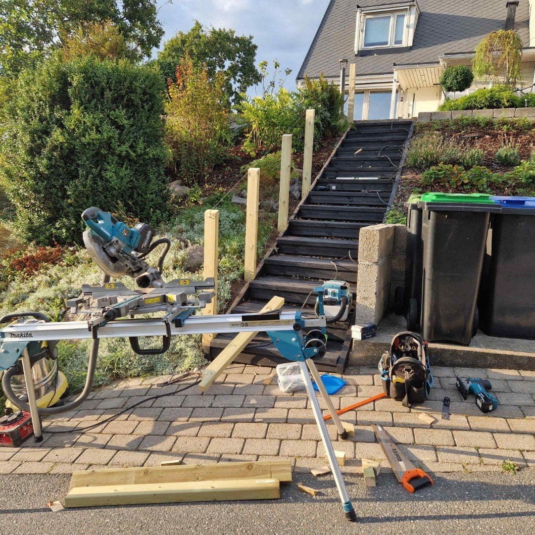 Snekkerverktøy og materialer under bygging av utendørs trapp i skråning, Son