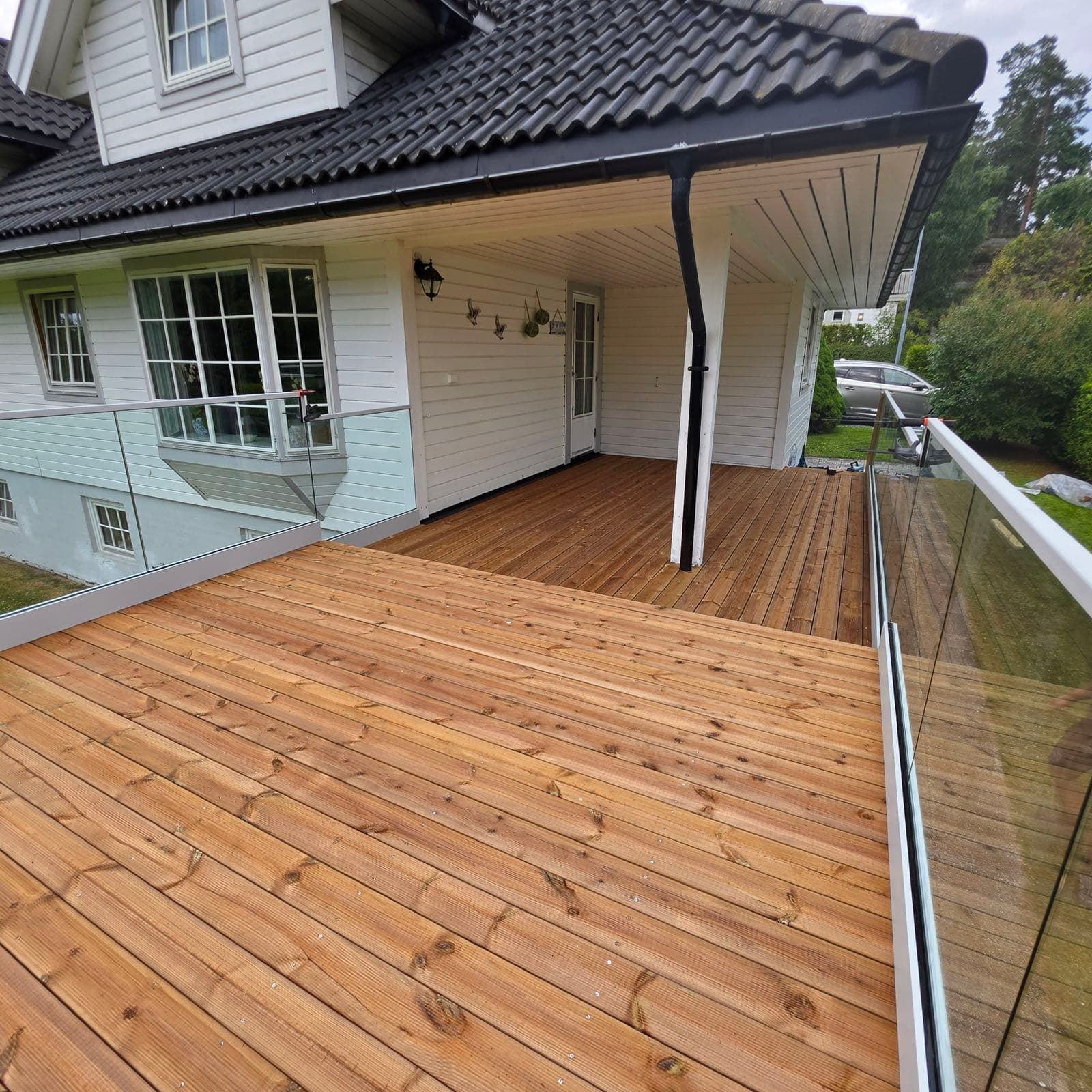 Ny terrassedekke med glassrekkverk bygget ut fra eksisterende overbygd terrasse, Son